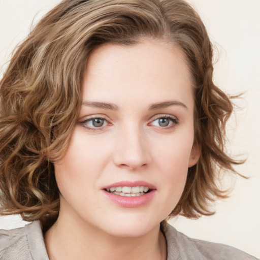 Joyful white young-adult female with medium  brown hair and blue eyes