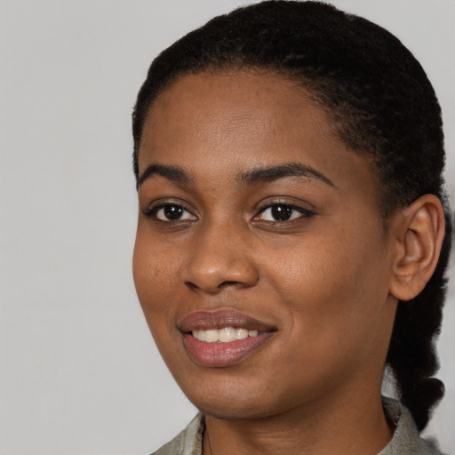 Joyful black young-adult female with short  black hair and brown eyes