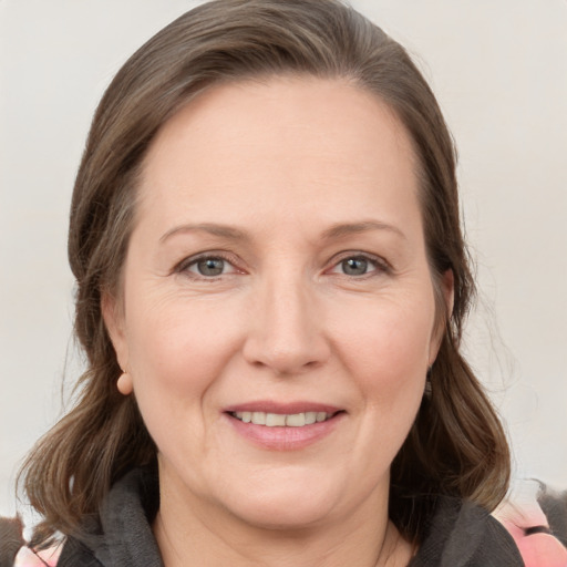 Joyful white adult female with medium  brown hair and grey eyes