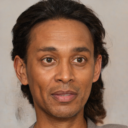 Joyful black adult male with medium  brown hair and brown eyes