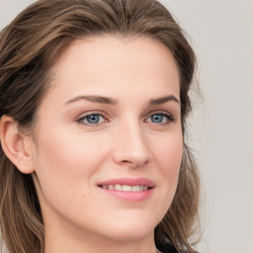 Joyful white young-adult female with long  brown hair and blue eyes