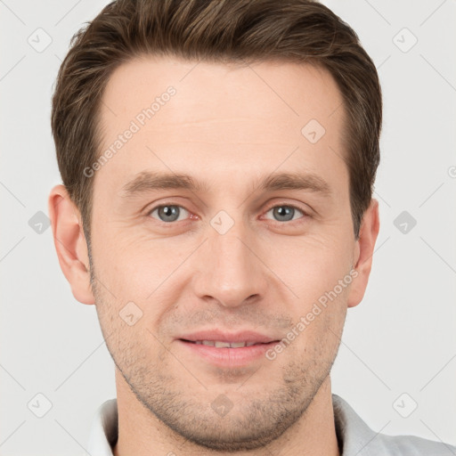 Joyful white young-adult male with short  brown hair and grey eyes