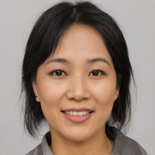 Joyful asian young-adult female with medium  brown hair and brown eyes