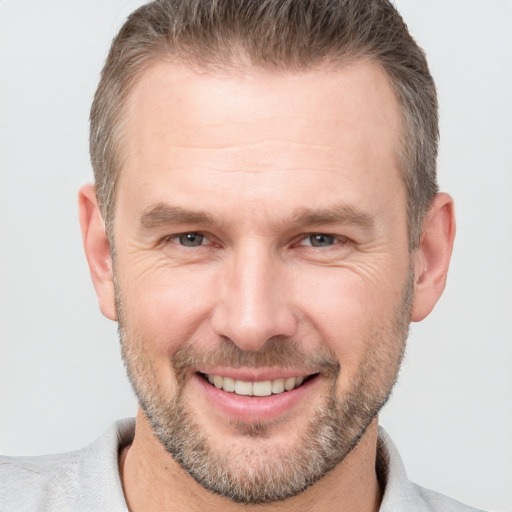 Joyful white adult male with short  brown hair and brown eyes