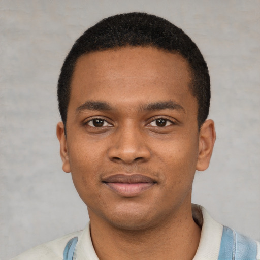 Joyful black young-adult male with short  black hair and brown eyes