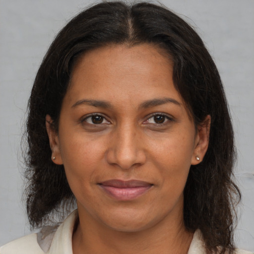 Joyful black adult female with medium  brown hair and brown eyes