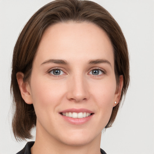 Joyful white young-adult female with medium  brown hair and grey eyes