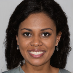 Joyful black young-adult female with long  brown hair and brown eyes