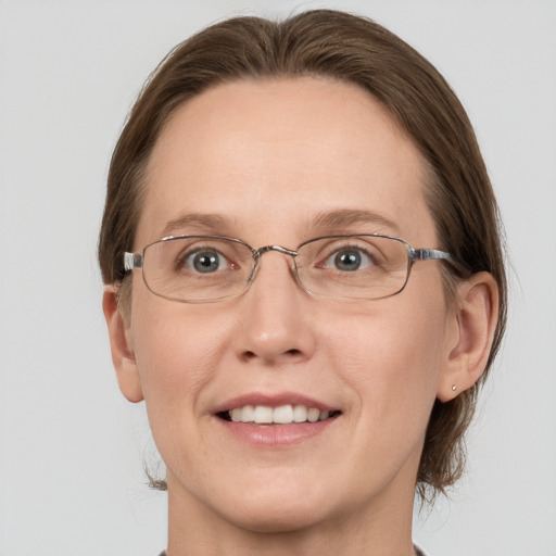 Joyful white adult female with medium  brown hair and grey eyes