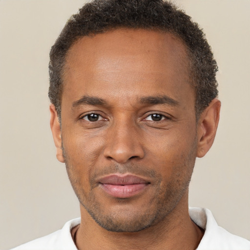 Joyful black adult male with short  brown hair and brown eyes