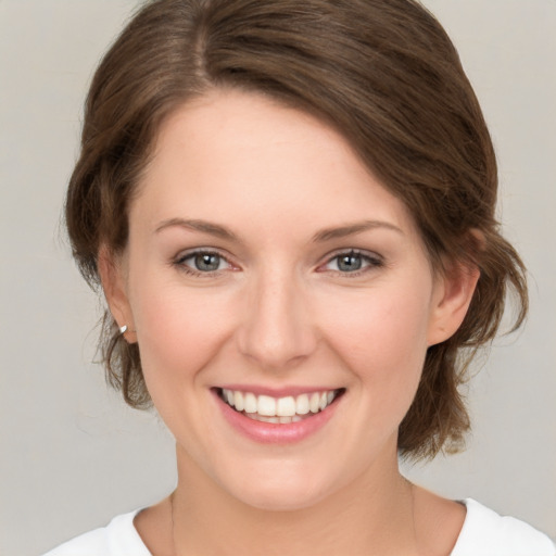 Joyful white young-adult female with medium  brown hair and green eyes