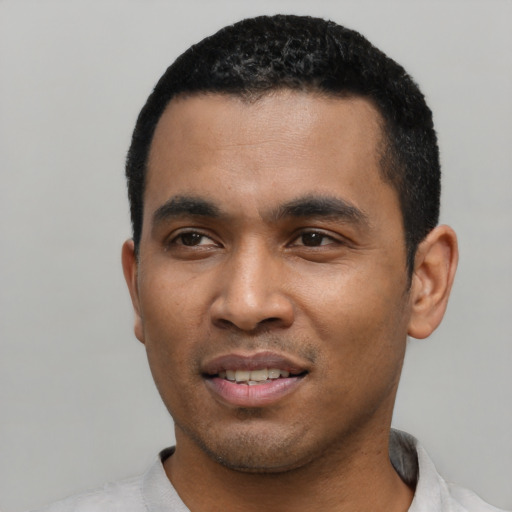 Joyful latino young-adult male with short  black hair and brown eyes