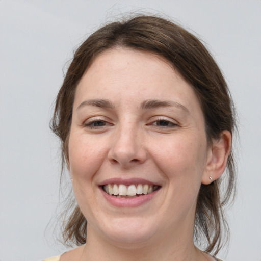 Joyful white adult female with medium  brown hair and grey eyes