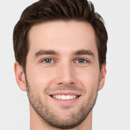 Joyful white young-adult male with short  brown hair and grey eyes