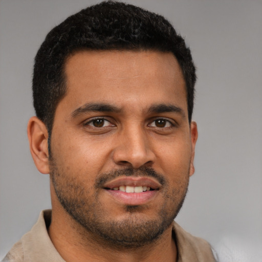 Joyful black young-adult male with short  brown hair and brown eyes