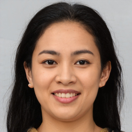 Joyful asian young-adult female with long  brown hair and brown eyes