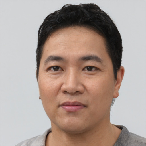 Joyful asian adult male with short  black hair and brown eyes