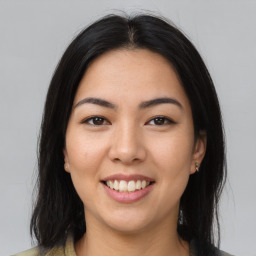 Joyful latino young-adult female with medium  brown hair and brown eyes