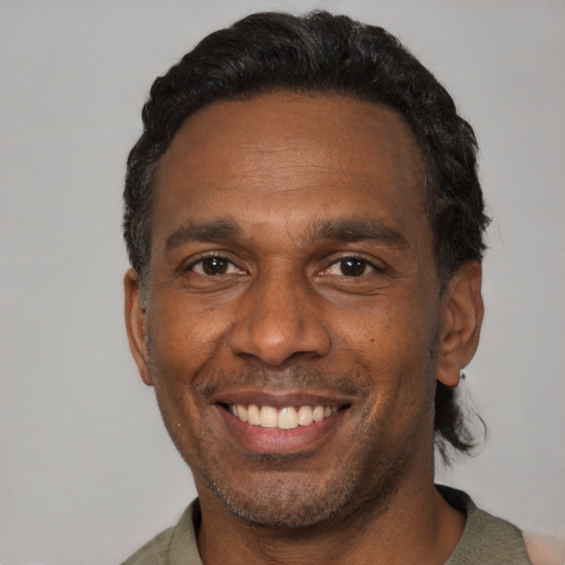 Joyful black adult male with short  black hair and brown eyes