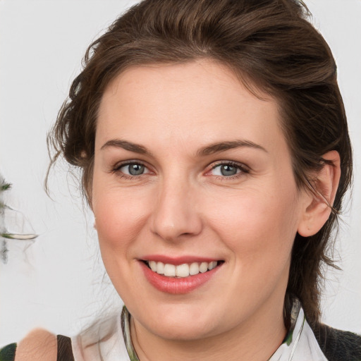 Joyful white young-adult female with medium  brown hair and green eyes