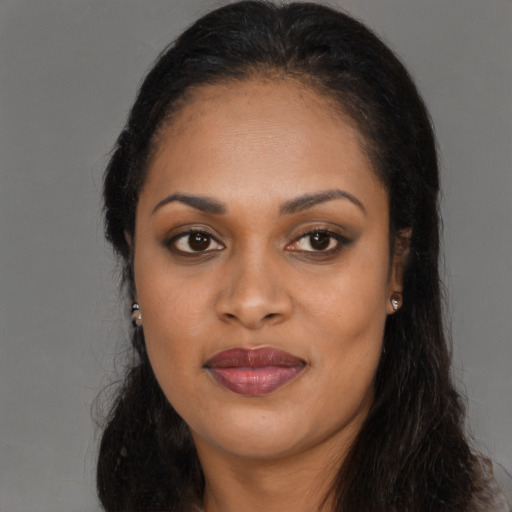 Joyful black young-adult female with long  brown hair and brown eyes
