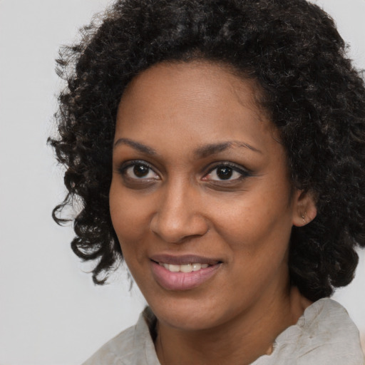 Joyful black young-adult female with medium  brown hair and brown eyes
