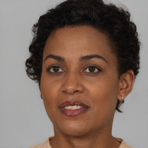 Joyful black young-adult female with short  brown hair and brown eyes