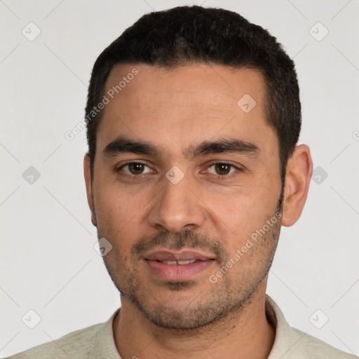 Joyful white young-adult male with short  black hair and brown eyes