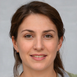 Joyful white young-adult female with medium  brown hair and green eyes