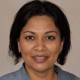 Joyful black adult female with medium  brown hair and brown eyes