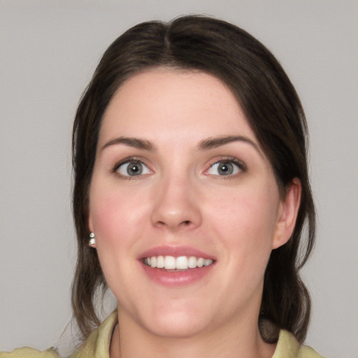 Joyful white young-adult female with medium  brown hair and green eyes