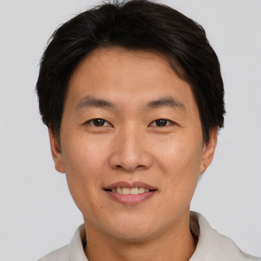 Joyful asian adult male with short  brown hair and brown eyes