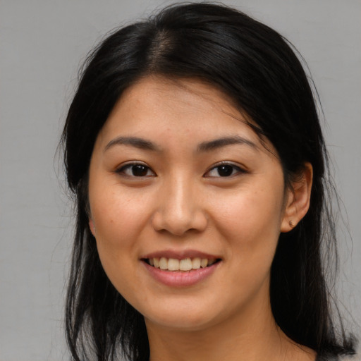 Joyful asian young-adult female with long  brown hair and brown eyes