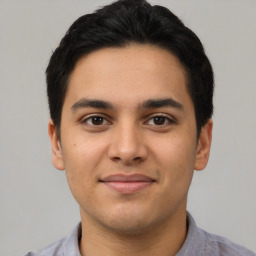 Joyful latino young-adult male with short  brown hair and brown eyes