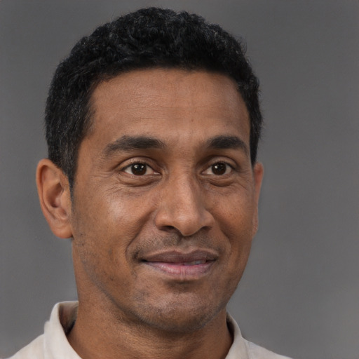 Joyful latino adult male with short  brown hair and brown eyes