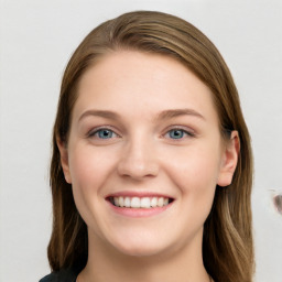 Joyful white young-adult female with long  brown hair and blue eyes