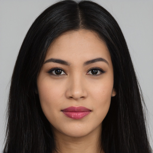 Joyful latino young-adult female with long  black hair and brown eyes