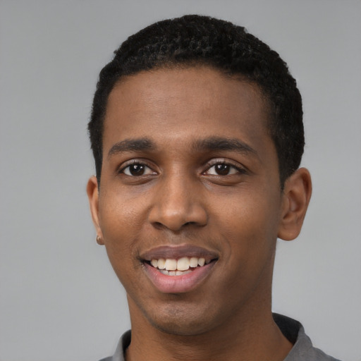 Joyful black young-adult male with short  black hair and brown eyes