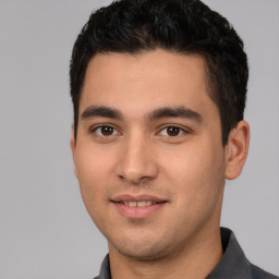 Joyful white young-adult male with short  black hair and brown eyes