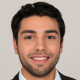 Joyful white young-adult male with short  black hair and brown eyes