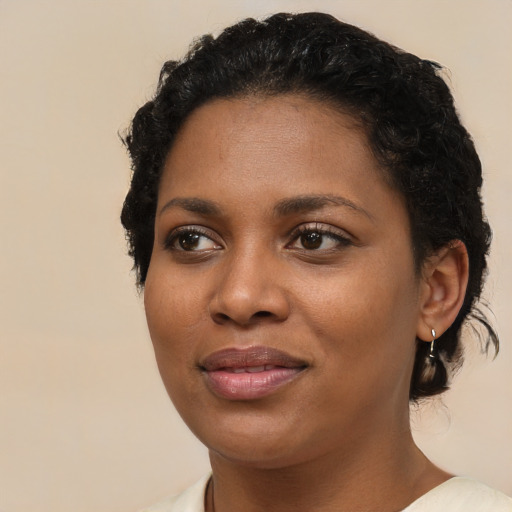Joyful black young-adult female with short  black hair and brown eyes