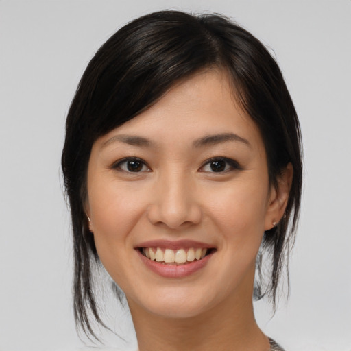 Joyful asian young-adult female with medium  brown hair and brown eyes