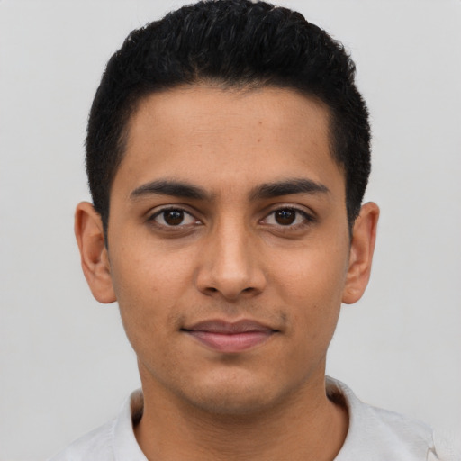 Joyful latino young-adult male with short  black hair and brown eyes