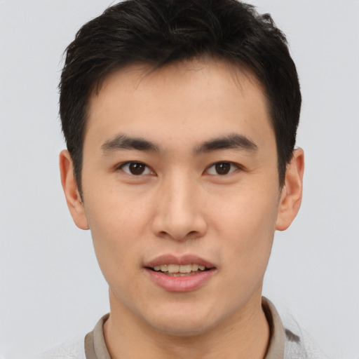 Joyful asian young-adult male with short  brown hair and brown eyes