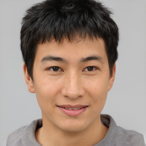 Joyful asian young-adult male with short  brown hair and brown eyes