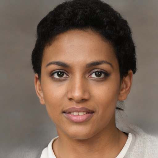 Joyful black young-adult female with short  black hair and brown eyes