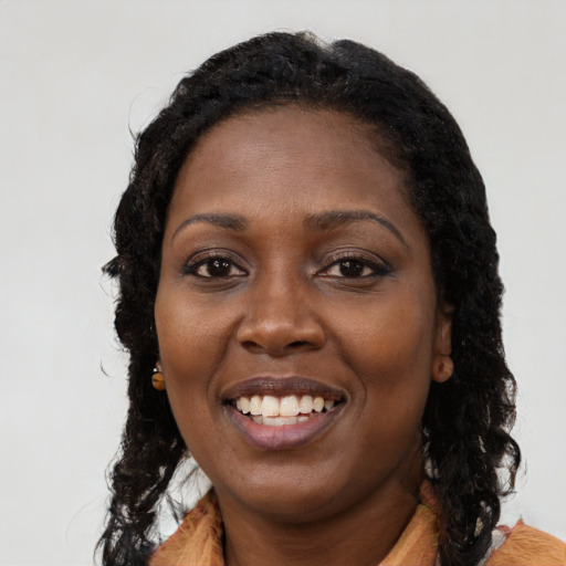 Joyful black young-adult female with long  black hair and brown eyes