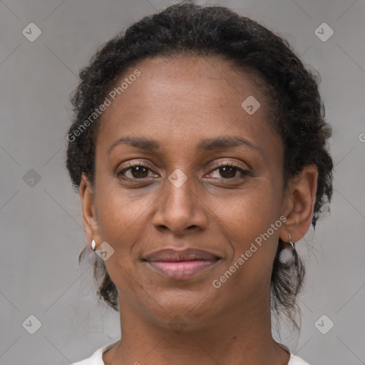 Joyful black adult female with medium  brown hair and brown eyes