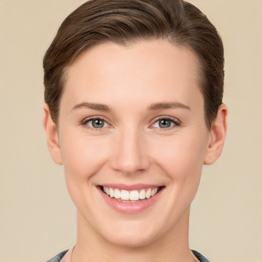 Joyful white young-adult female with short  brown hair and grey eyes