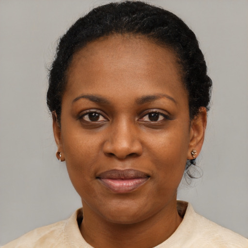 Joyful black young-adult female with short  black hair and brown eyes
